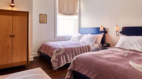 Guest room with two beds, a wooden wardrobe and a window