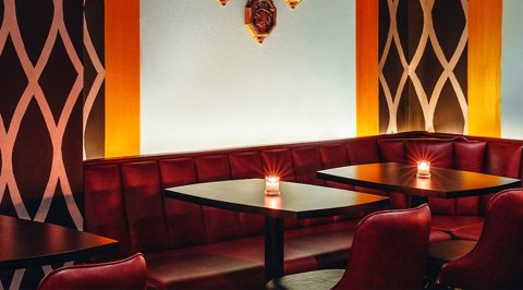 Red booths and candlelit tables in one of the hotel's bars