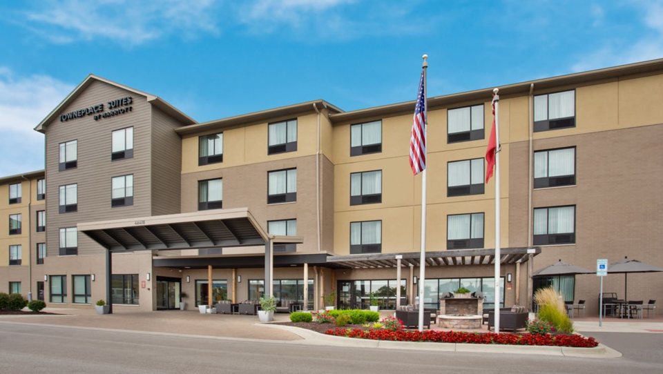 The hotel's four-storey building with the entrance canopy, flagpoles and flower beds