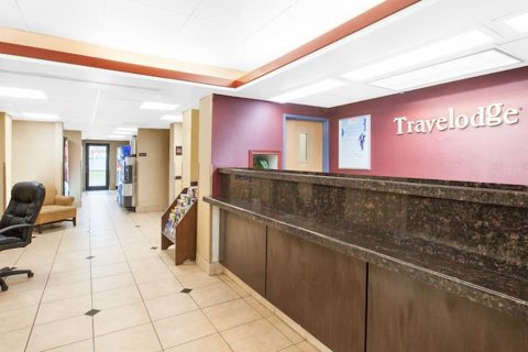 The front desk with a granite counter and the Travelodge sign on the wall