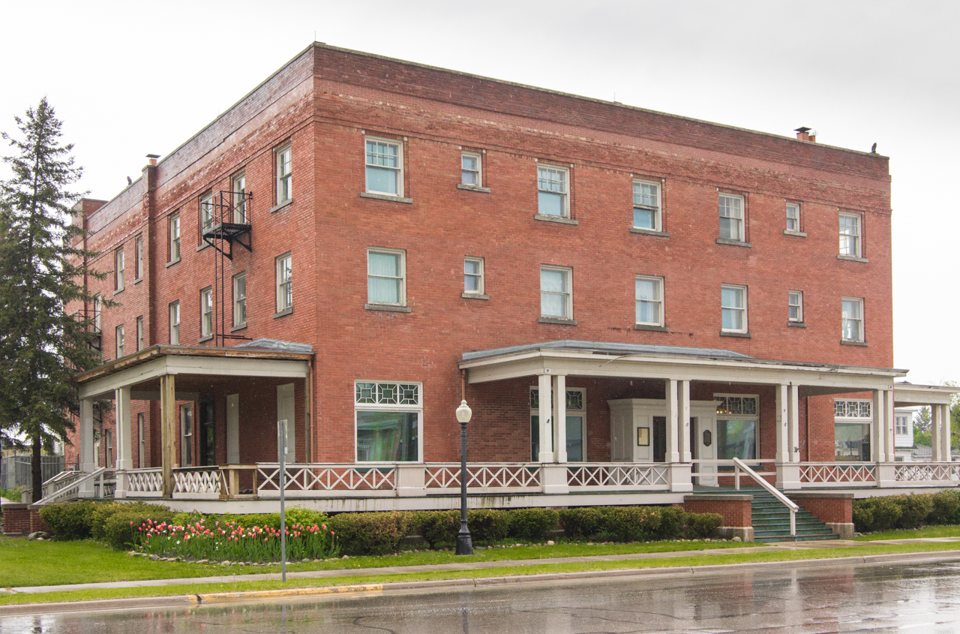 A Wolverine Hotel háromszintes vöröstégla épülete körbefutó tornáccal a Water Streeten, 2015