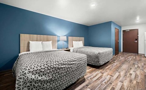 Guest room with two beds, a blue wall and patterned bedspreads