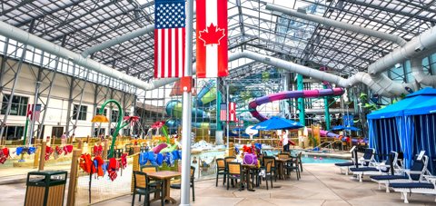The indoor waterpark's glass-roofed hall with tables and flags