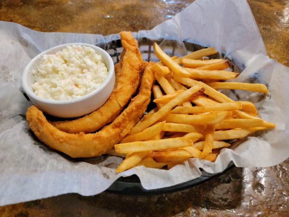 Fried fish with fries and coleslaw in a paper-lined basket