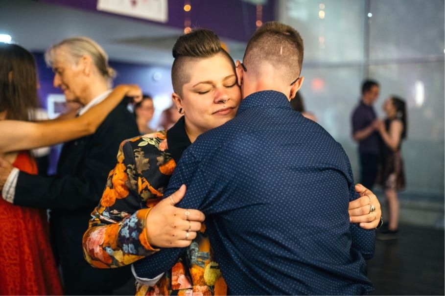 Két ember öleli egymást egy táncos közösségi esten