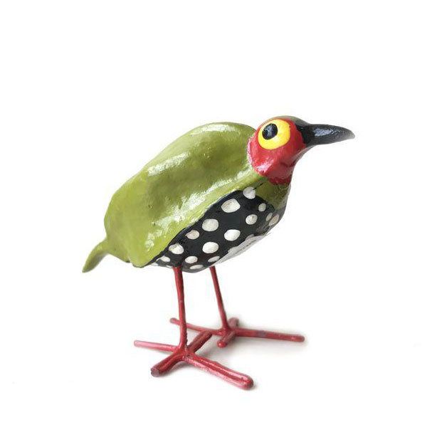 Handmade green polka-dot bird sculpture on thin red metal legs