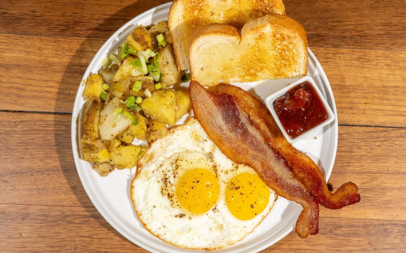 Reggelizőtányér tükörtojással, baconnel és pirított burgonyával
