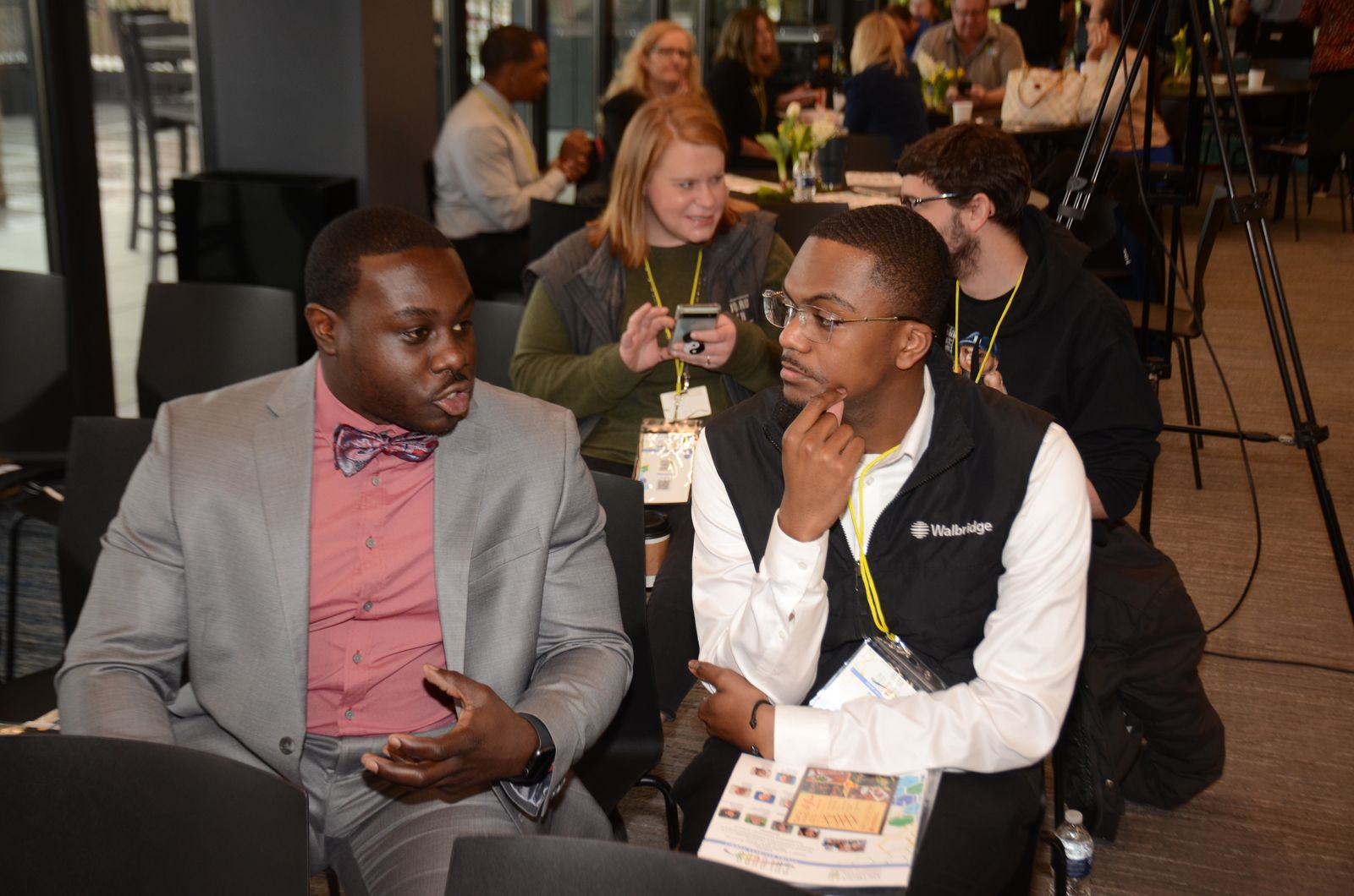 Attendees with lanyards chat at a Michigan Pride Chamber networking event
