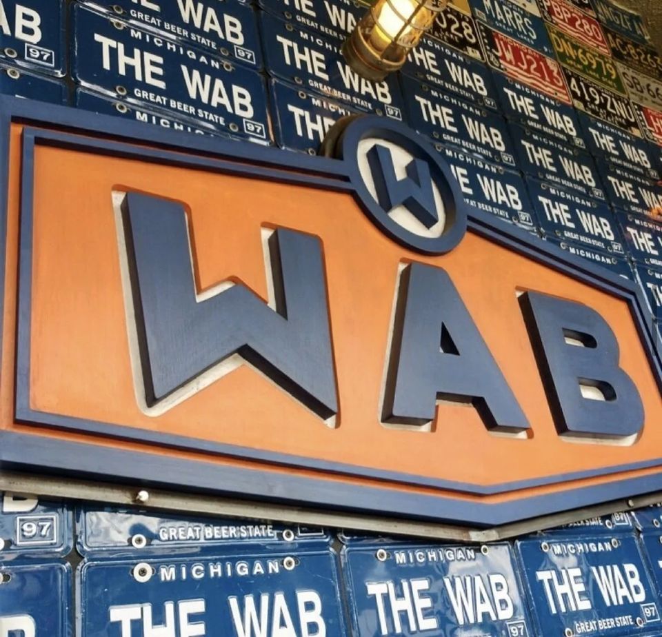 A The WAB narancs-kék cégére rendszámtáblákkal borított falon