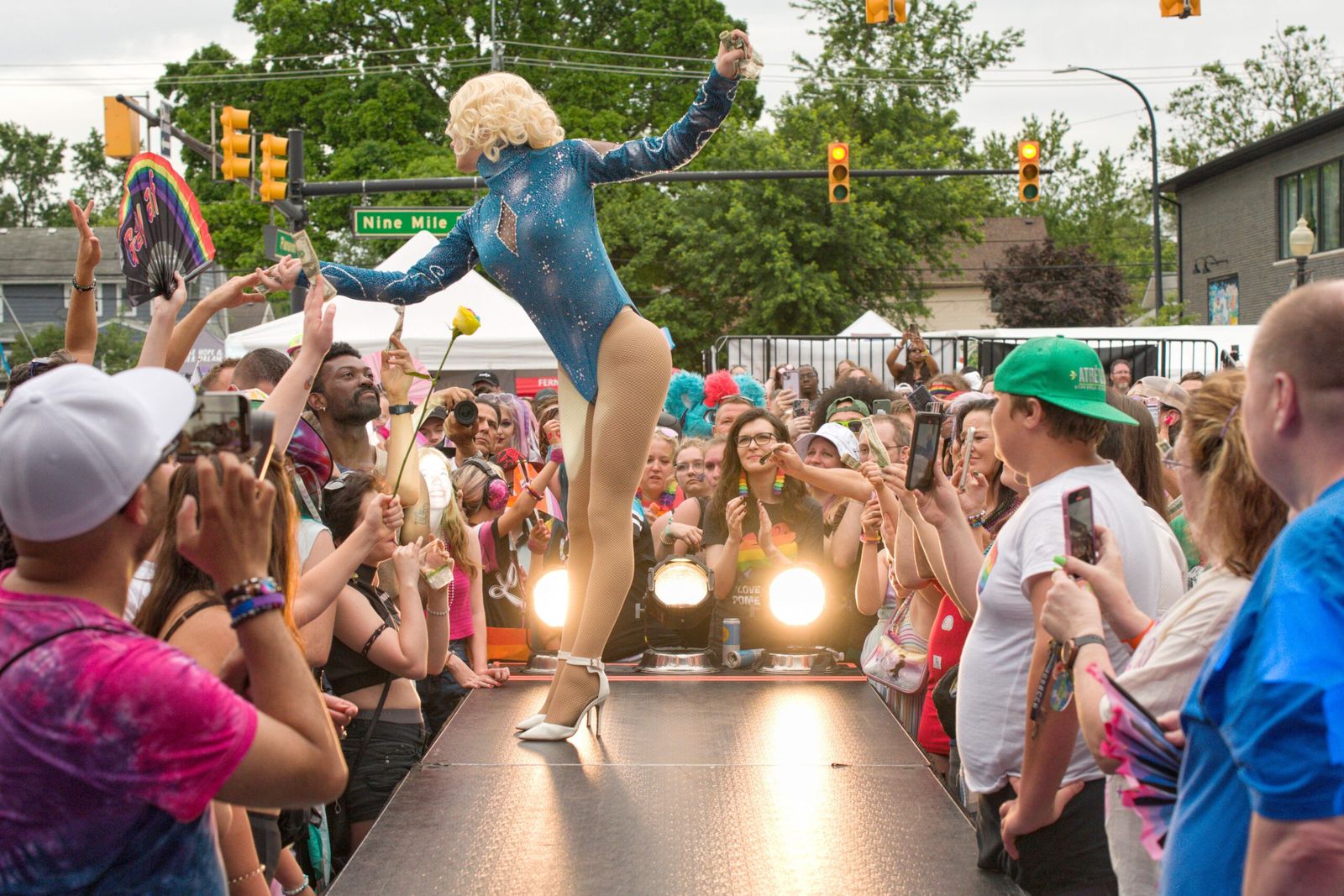 Drag-előadó csillogó kék dresszben a Ferndale Pride kifutóján, körben a tömeg