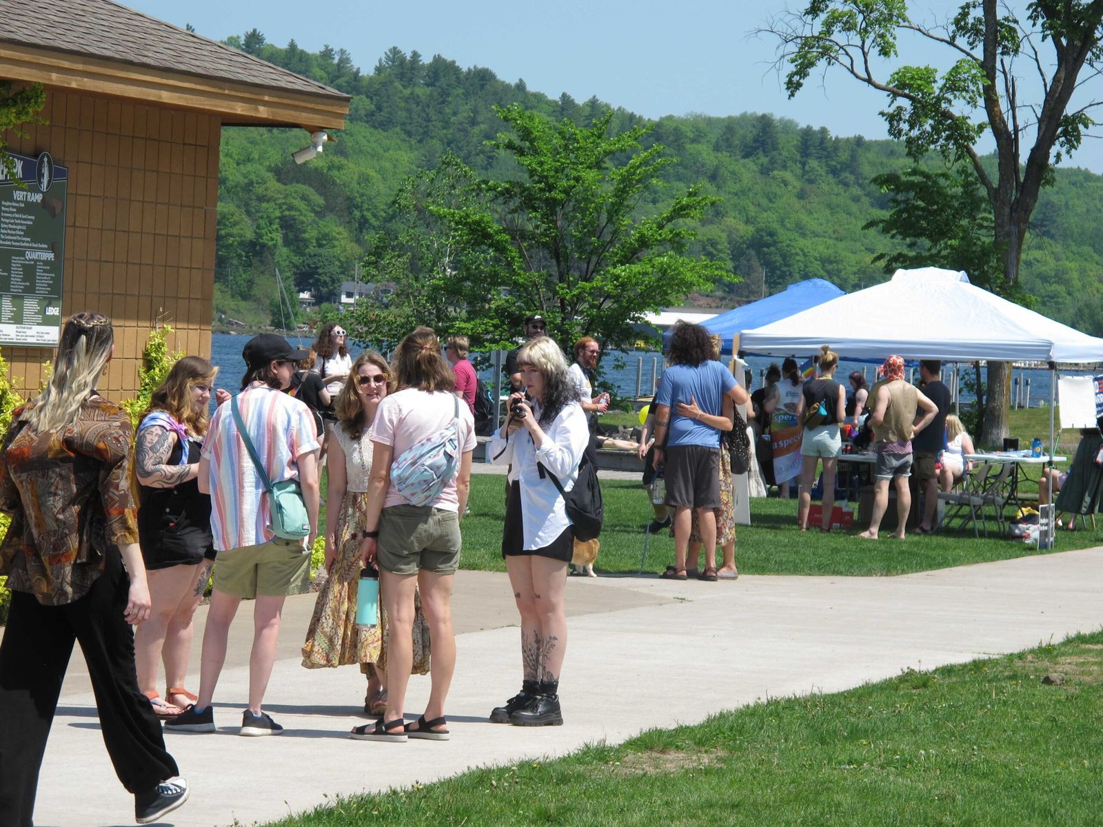 Fesztiválozók a Keweenaw Pridefest tóparti parkjában, sátrakkal