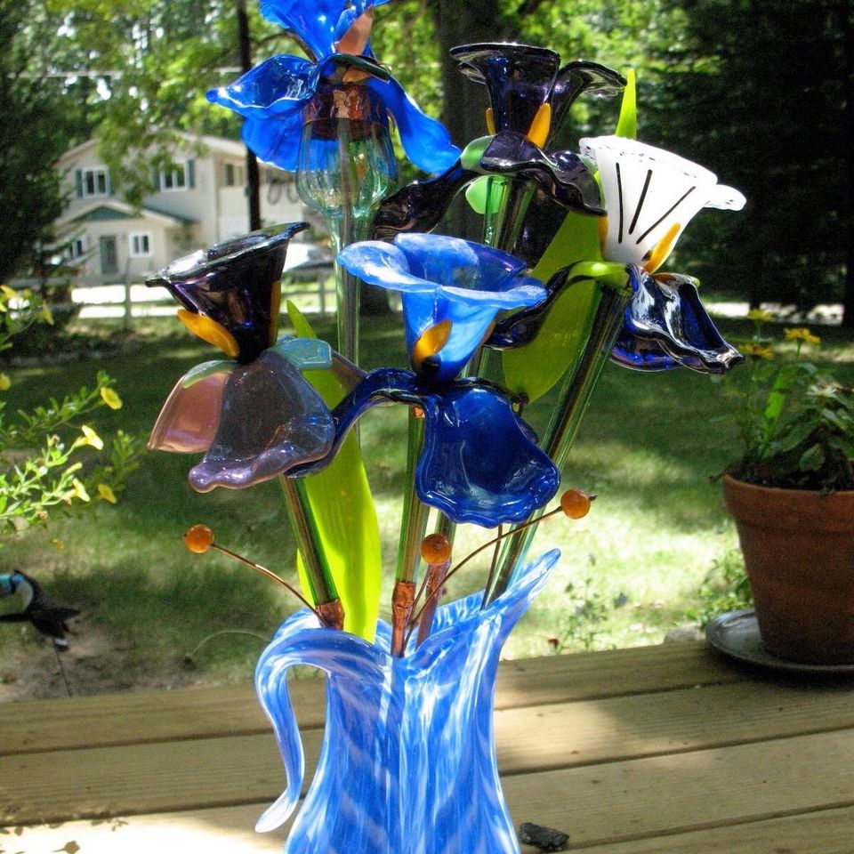 Blue and white glass calla lilies and irises in a swirled blue glass vase