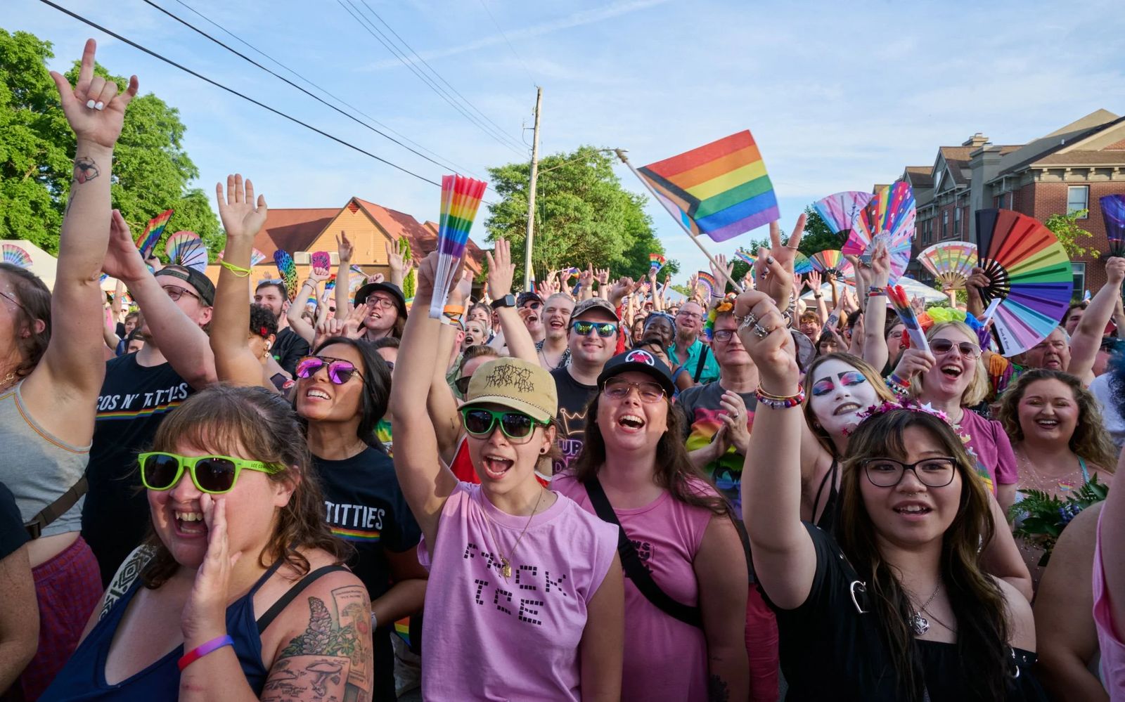 Ujjongó tömeg szivárványzászlókkal és legyezőkkel a Lansing Pride-on