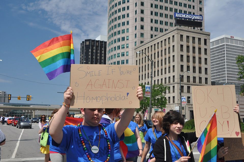 Felvonulók táblákkal és szivárványzászlóval a 2012-es Motor City Pride-on
