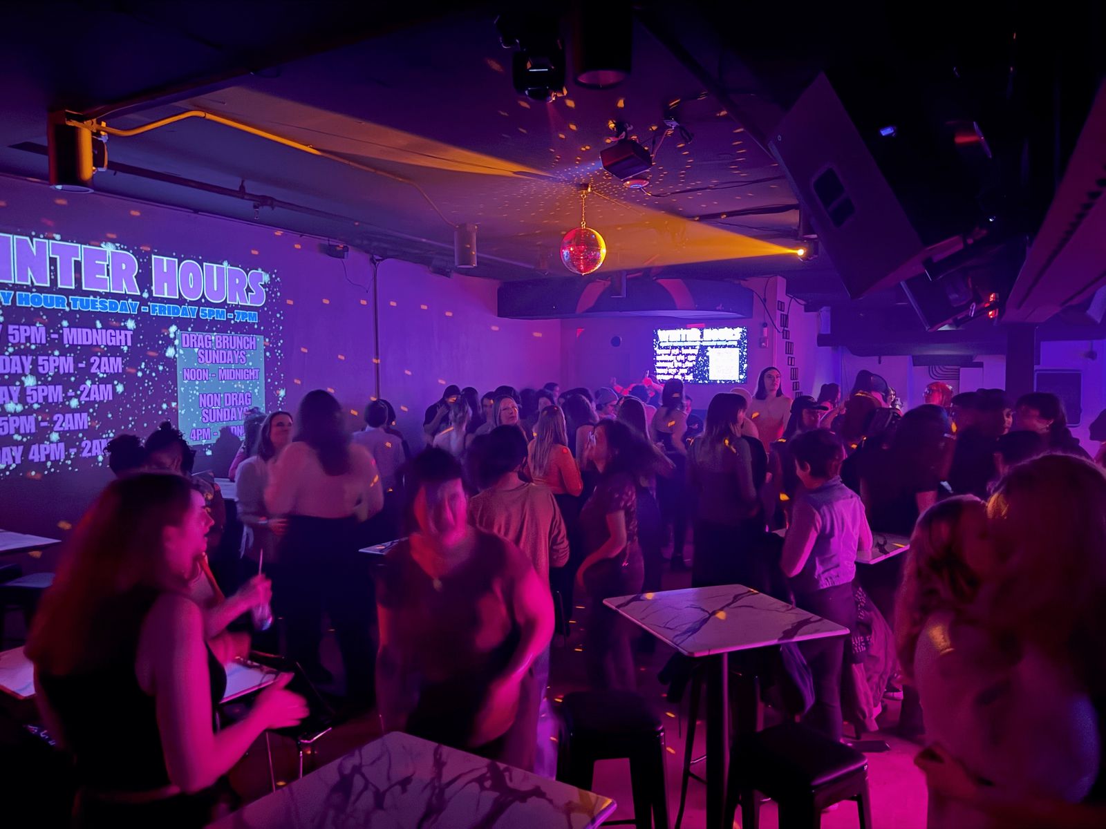 Crowded, purple-lit club floor full of guests at Uplift