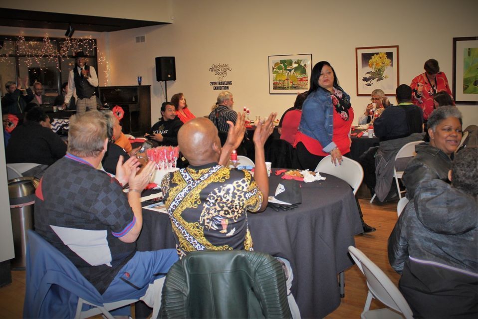 Guests applaud at round tables during a World AIDS Day evening gathering