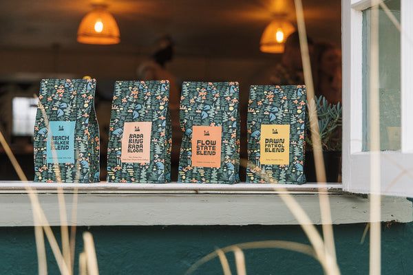 Four patterned bags of Woosah coffee blends lined up on a windowsill
