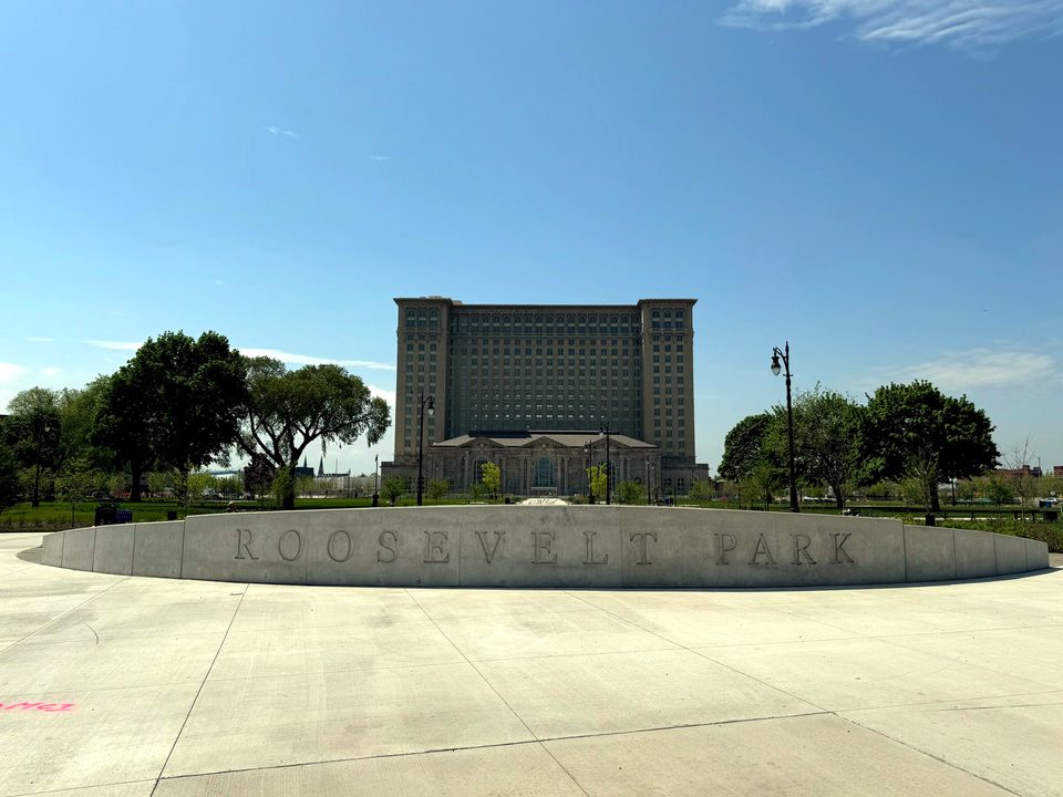 The curved Roosevelt Park wall with the station behind, 2024