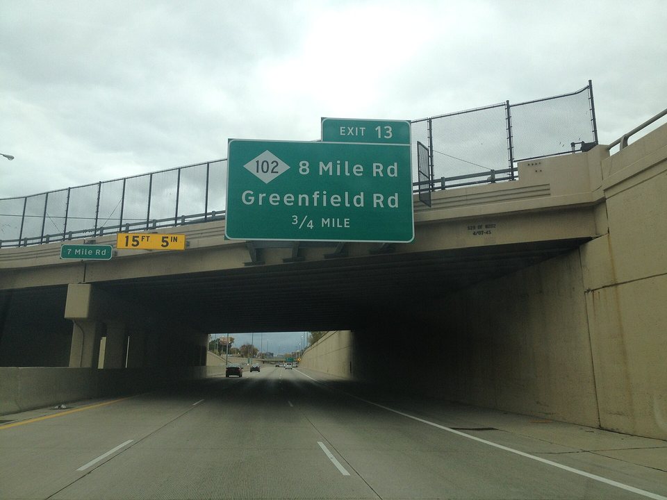 A 7 Mile Rd sign seen from the freeway