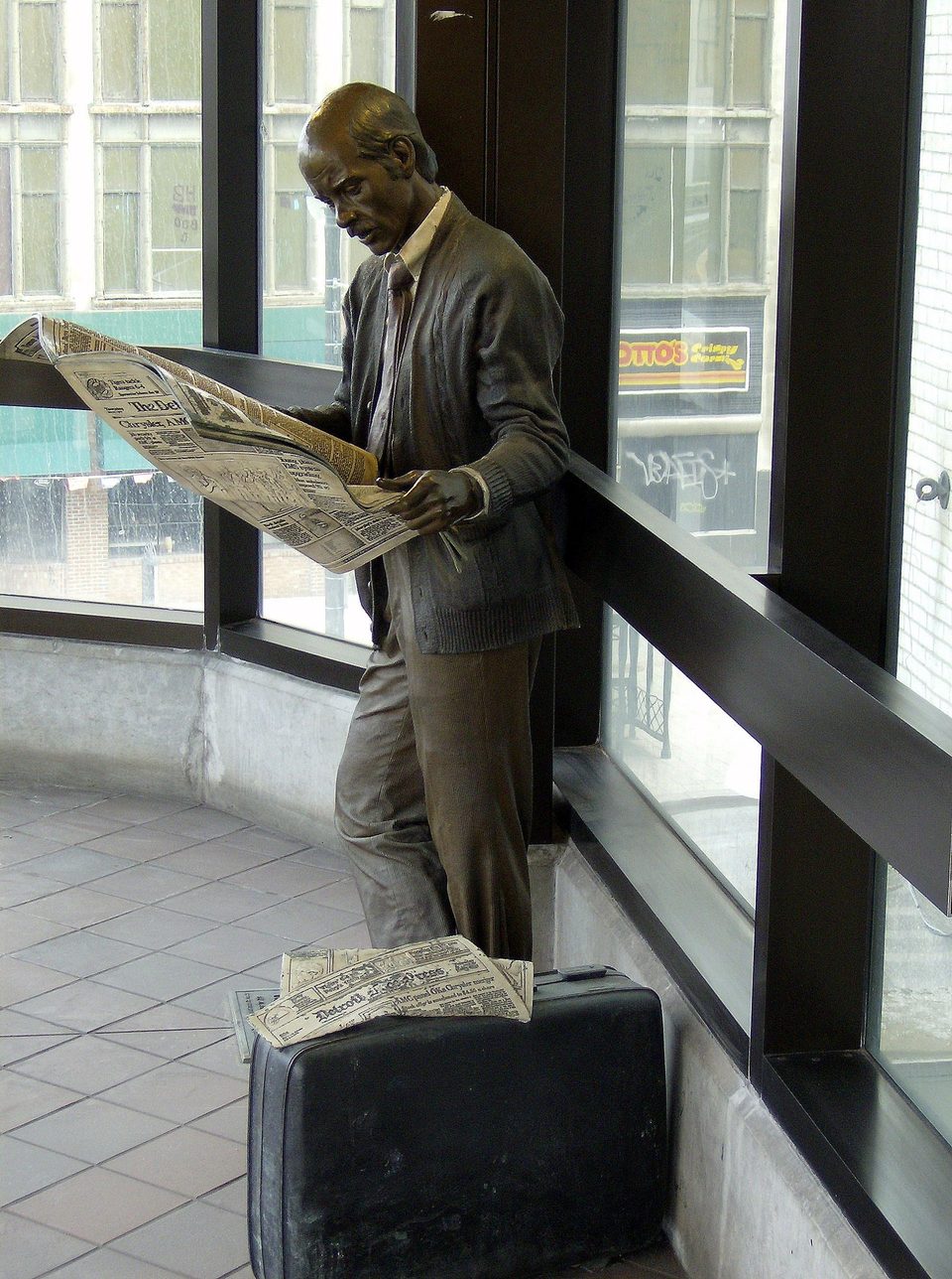 J. Seward Johnson „Catching Up” című bronzszobra: az újságot olvasó utas