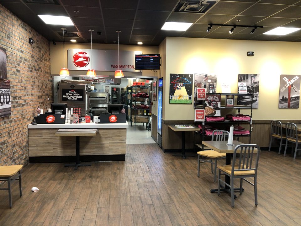 A carryout-style Pizza Hut inside today, 2023: a counter and a few chairs