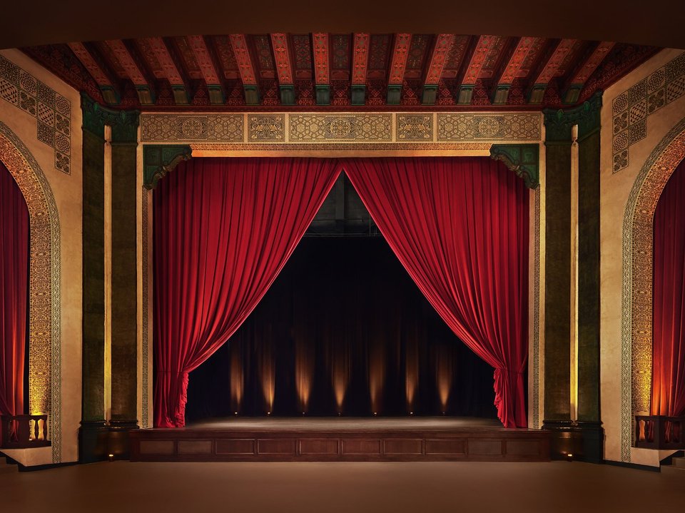 The stage with its red velvet curtain and ornate proscenium