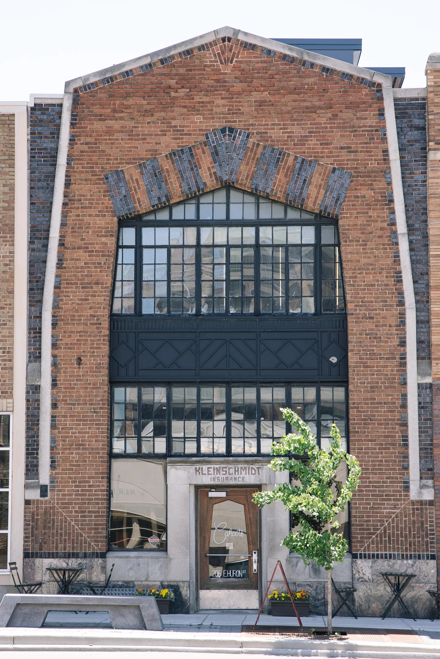 Cahoots' brick facade on Huron Street, with tall gridded windows and old Kleinschmidt Insurance lettering over the door