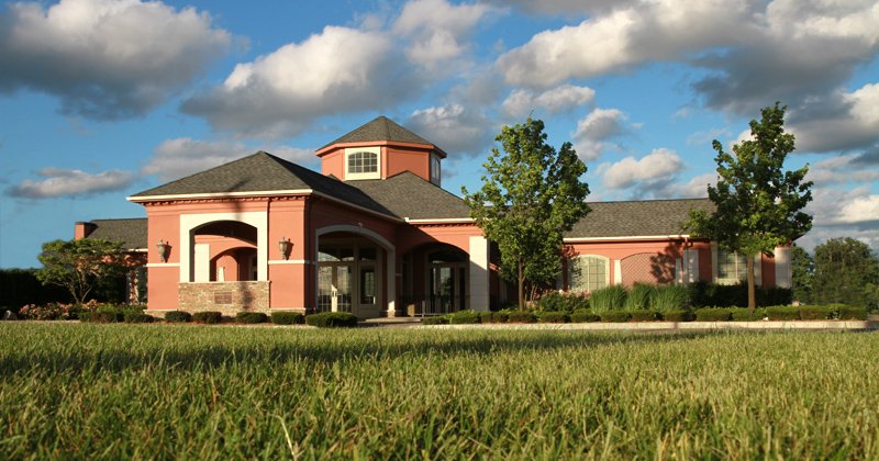 The building across the lawn under a summer sky
