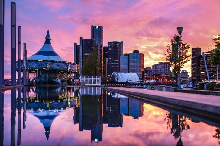 The carousel and the Renaissance Center reflected in the fountain pool at sunset