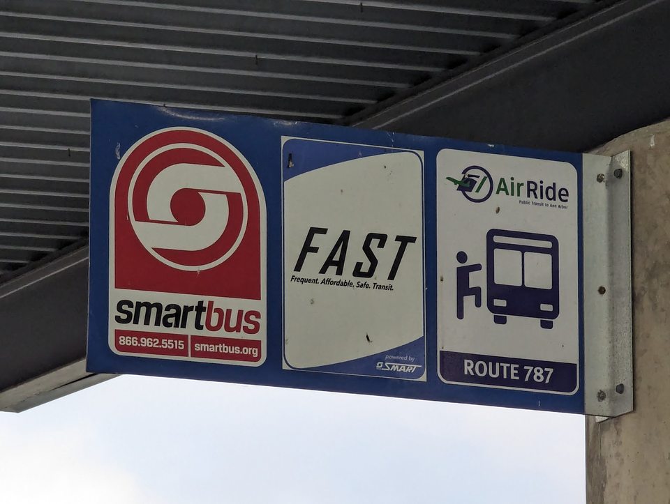 Tömegközlekedési táblák az Evans terminálnál: a SMART busz, a FAST és az AirRide 787-es járat megállója.