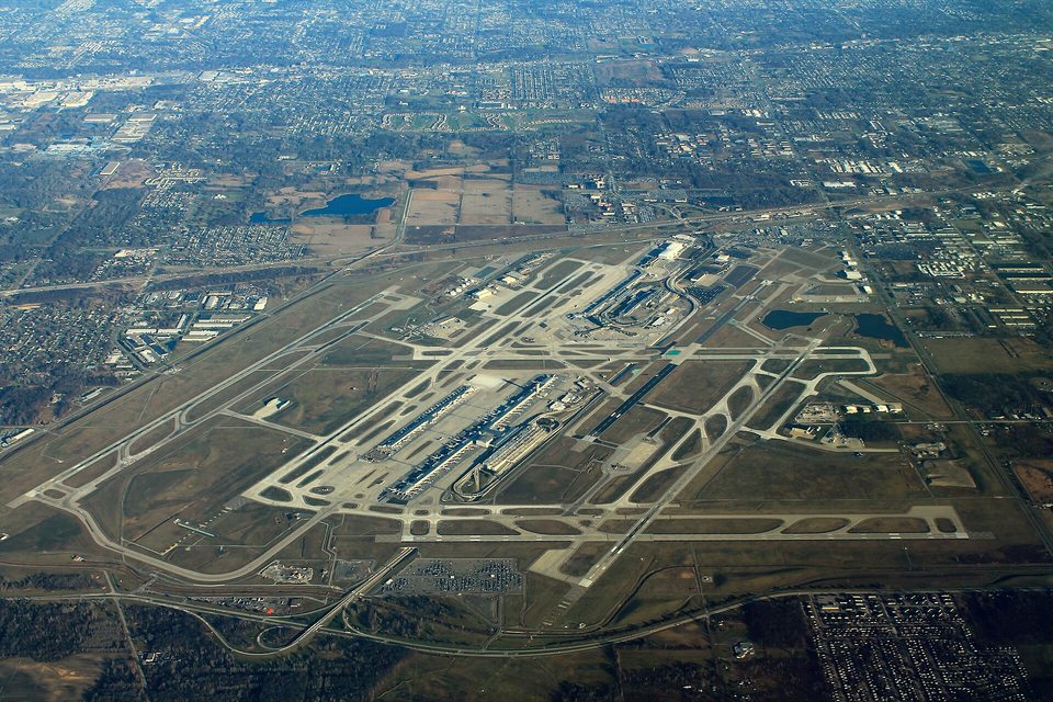 Légifotó a Detroit Metro Airportról: párhuzamos kifutópályák, gurulóutak és a terminálkomplexum a környező elővárosok között.