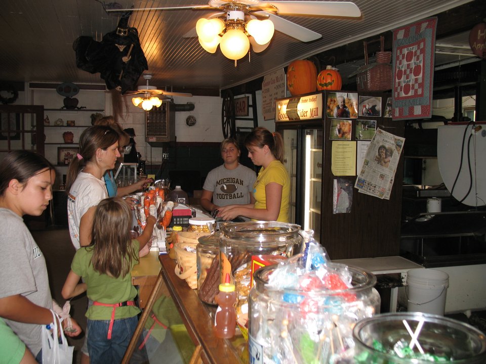 Customers at the counter behind jars of old-fashioned candy