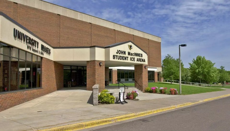 The brick entrance of the John MacInnes Student Ice Arena with flower beds