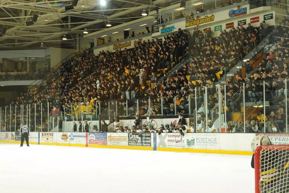 Fans in black and gold fill the stands behind the ice