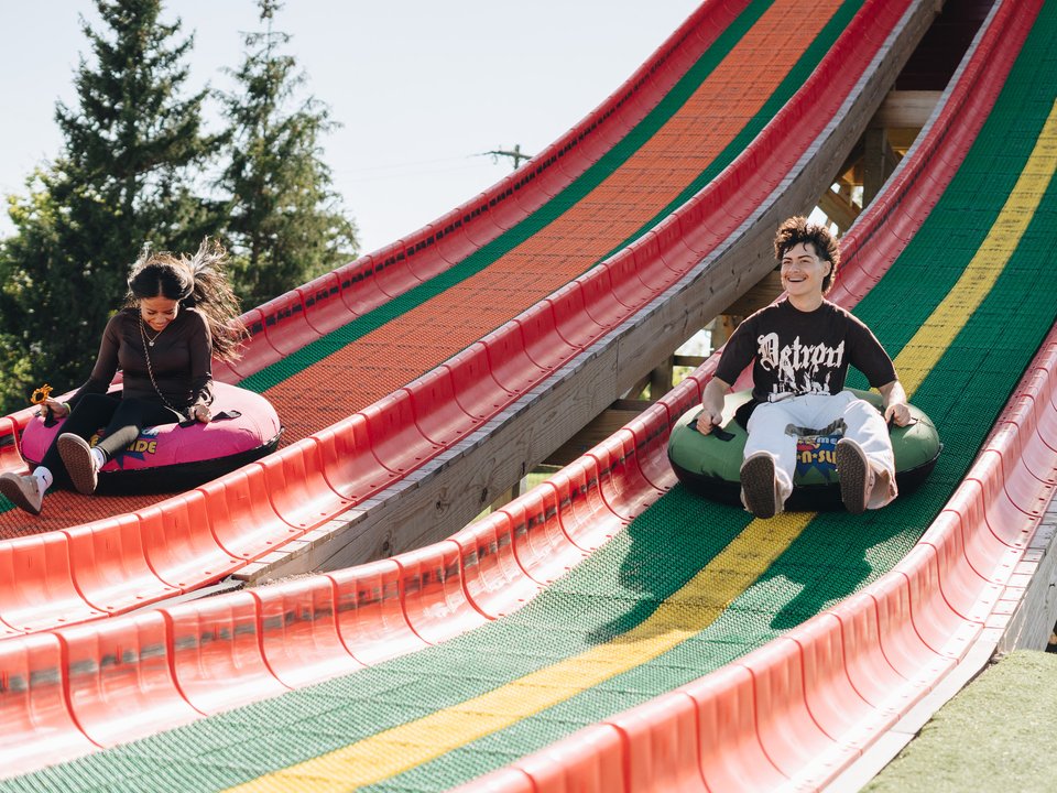 Kids riding tubes down the striped Super-Mega Slide