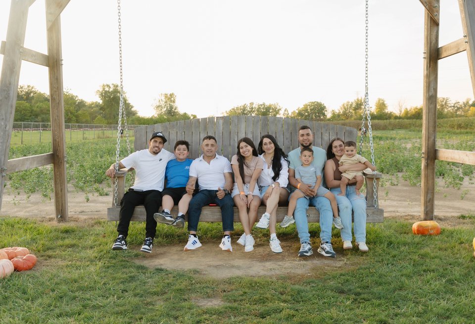 A family sitting together on the farm's giant swing
