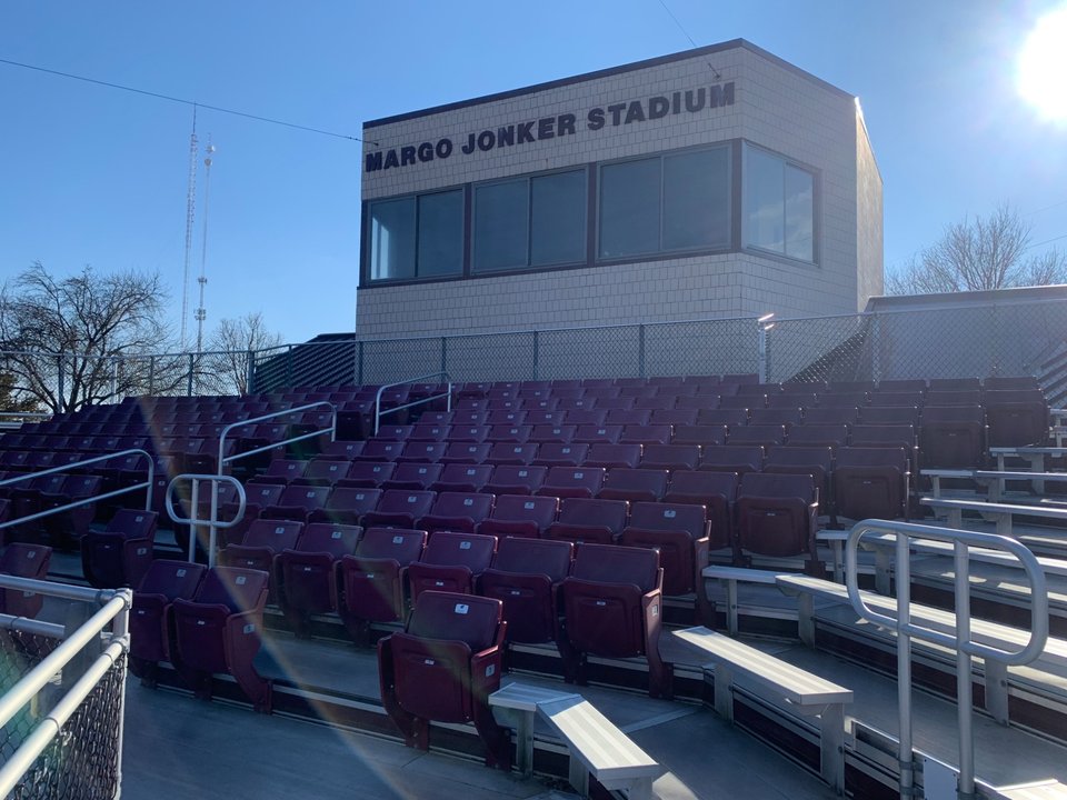 The press box marked Margo Jonker Stadium above the chairback seating