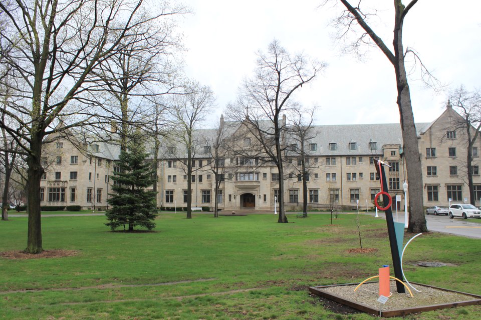 The long stone Madame Cadillac Hall across the campus lawn