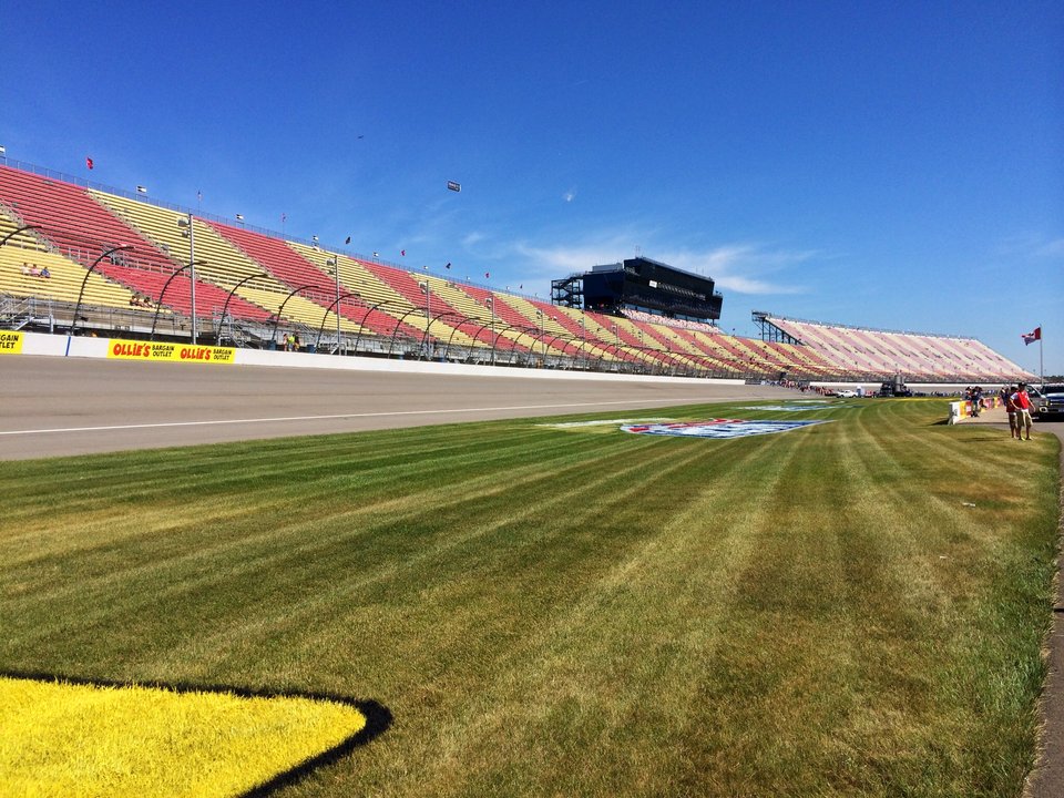 The front stretch and red-and-yellow grandstands seen from the infield on race morning
