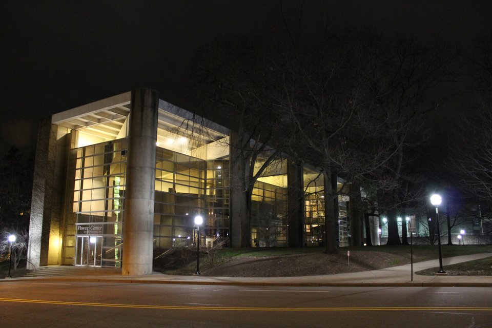 The Power Center lit up at night, its lobby glowing through the glass wall
