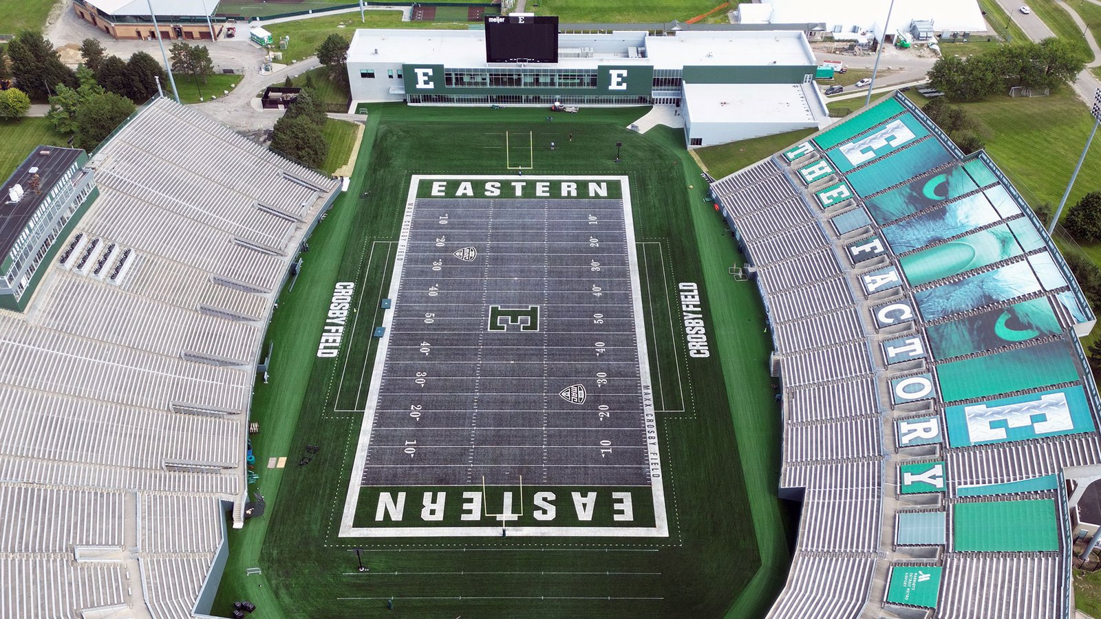 A Rynearson Stadium felülről: szürke műfű EASTERN felirattal, mellette a The Factory feliratú lelátó