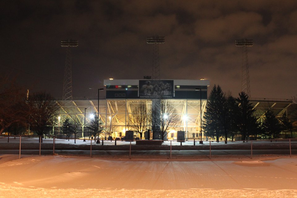 A Rynearson Stadium kivilágított nyugati lelátója és sajtóboxa egy havas téli éjszakán