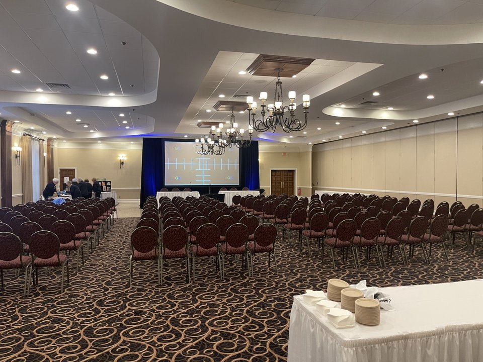 Rows of chairs and a projection screen set up for a corporate event