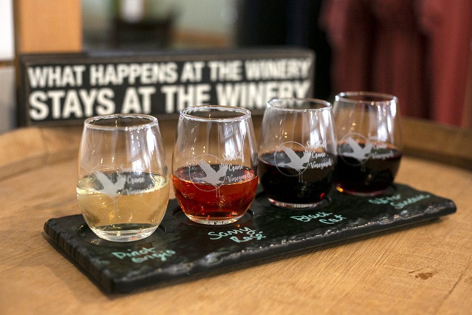 A four-glass wine flight on a slate board