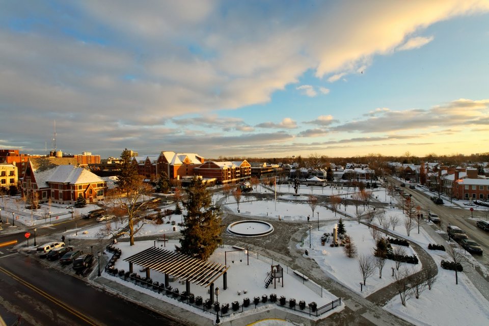 A snowy Shain Park at sunset with downtown Birmingham behind it
