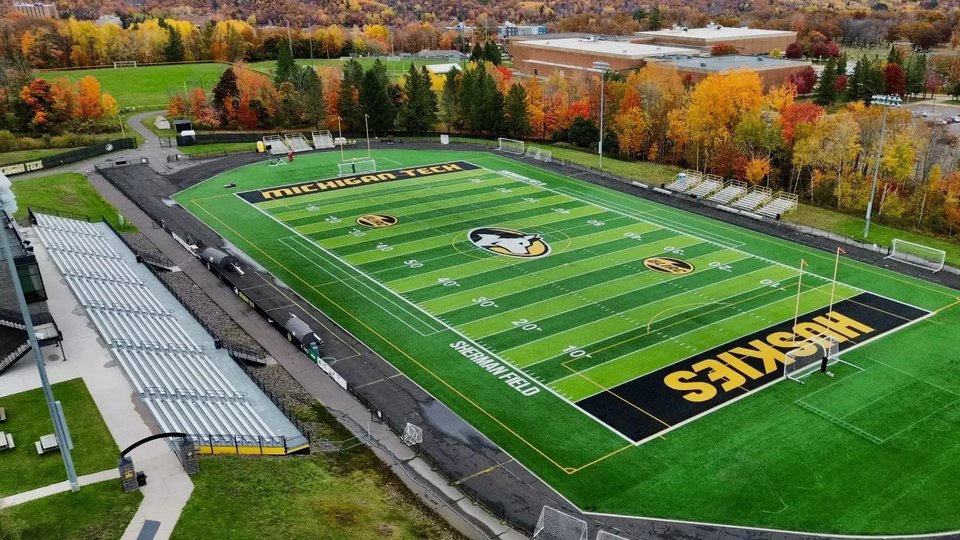 The turf at Sherman Field and the grandstand from above, campus buildings behind