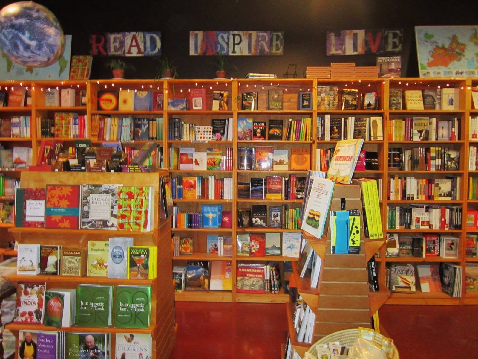 Inside the shop: orange shelves packed with books under the words Read, Inspire, Live
