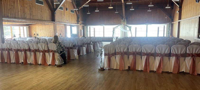 Event room with a wood floor and covered chairs