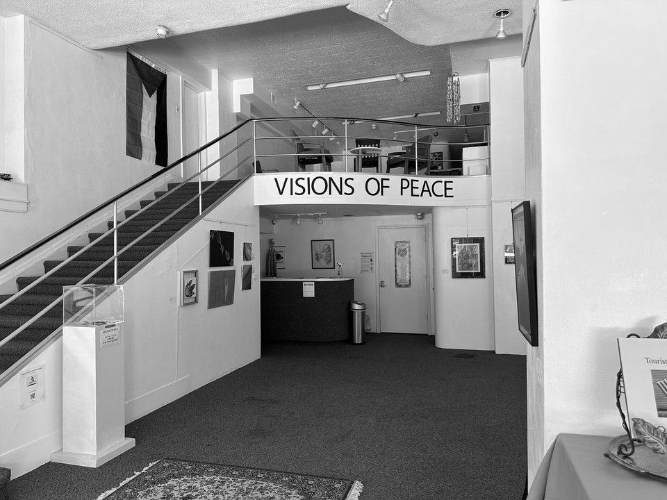 Black-and-white view of the gallery space with its stairs and mezzanine