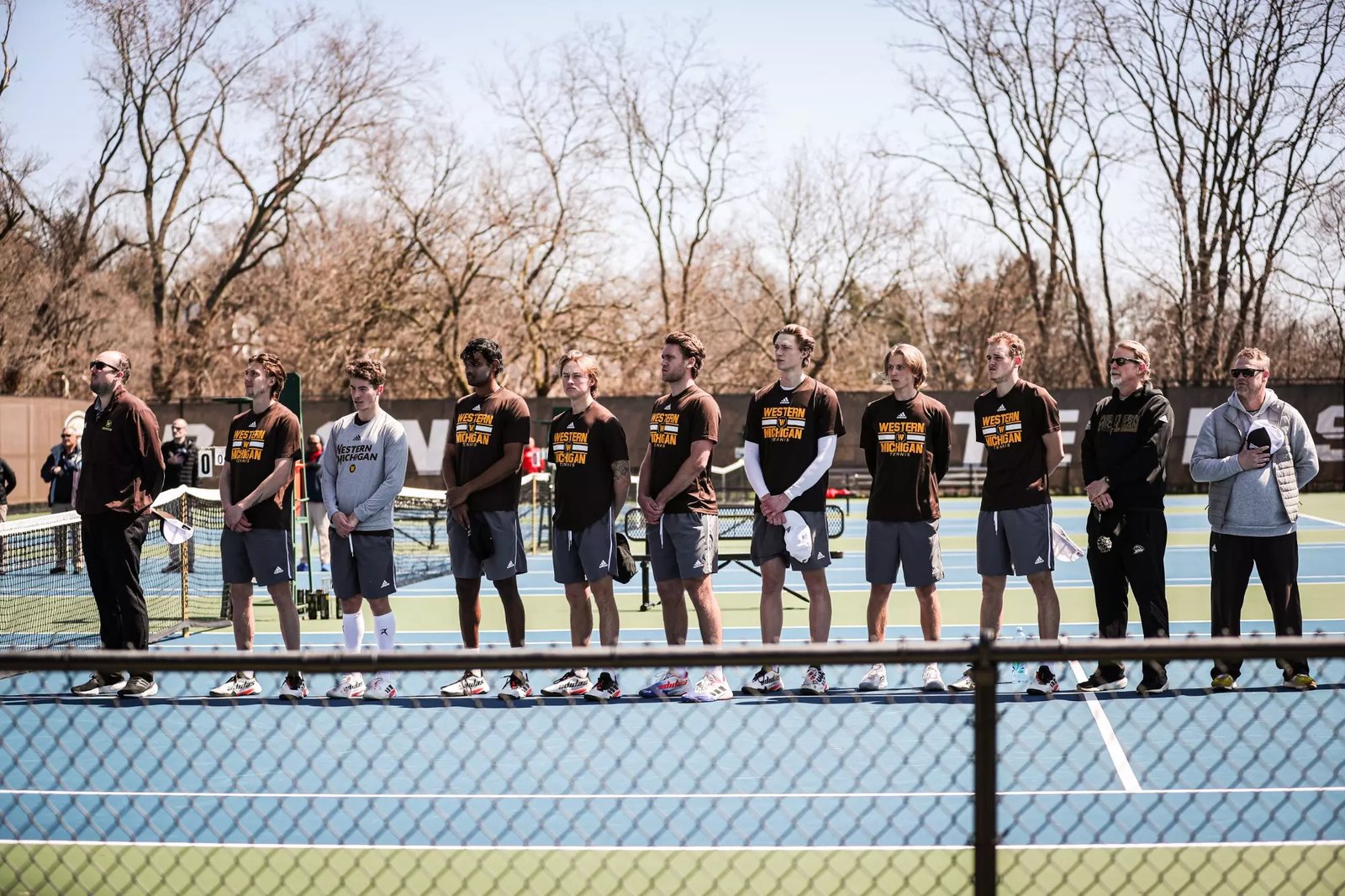 The Bronco men's tennis team lined up on the blue outdoor courts at Sorensen